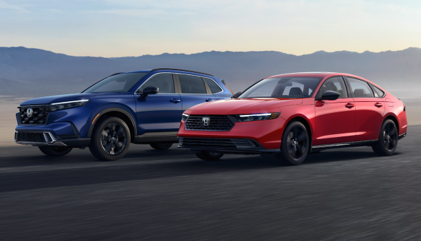 Un VUS Honda bleu et une berline Honda rouge stationnés côte à côte sur un tronçon de route dégagé.