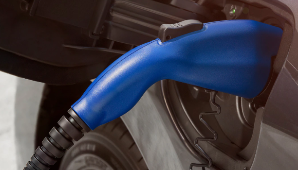 Un gros plan d’un pistolet à essence dans le réservoir de carburant d’un véhicule Honda est montré.