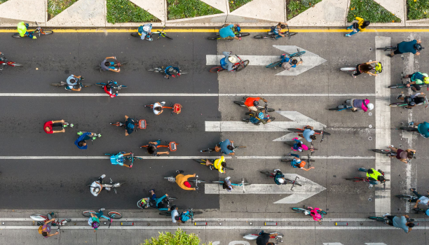 Un plan de plongée montre un groupe de cyclistes dans la rue d’une ville.
